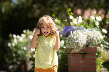 Little child play on summer backyard. Portrait of kid in spring park outdoors. Close-up face child playing outdoors in summer park. - 786953900