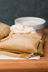 Central American tradition: savory tamales wrapped in corn leaves, served with creamy goodness, a taste of El Salvador