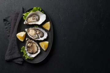 Fensteraufkleber Fresh oysters with lemon on plate © karandaev