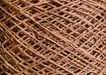 A skein of caramel-colored raffia is ready for knitting. Eco-friendly handmade material.