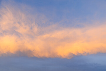 A serene sunset sky, awash with vibrant shades of orange and blue, creates a captivating backdrop,...