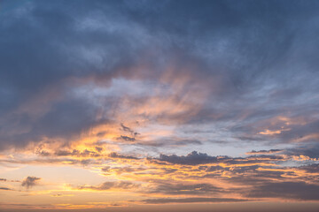 The sky at sunset is a breathtaking canvas of swirling blues and fiery oranges, creating a dramatic...