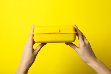 Yellow lunch box on a yellow background - obrazy, fototapety, plakaty