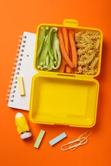 Rolgordijnen Yellow lunch box with delicious food and school supplies © Atlas