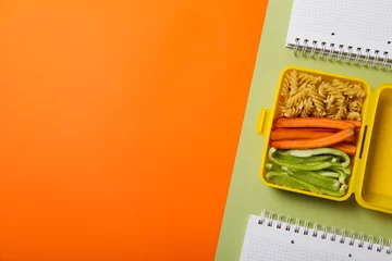 Foto op Canvas Yellow lunch box with healthy food and notebooks © Atlas