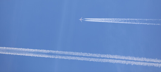 two double airplane tracks in the blue sky - 786972919