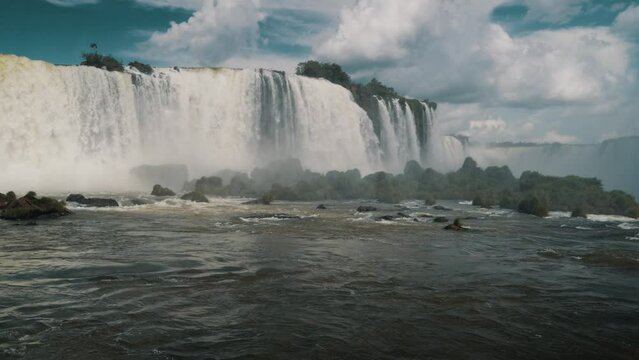 Fluffy White Clouds Over Iguazu Falls And River In Brazil And Argentina. - wide shot 
