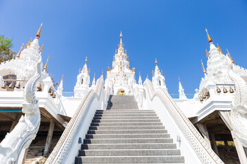 Beautiful white temple with clear blue sky background, Traditional Northern Thailand style temple, building and architecture concept, summer outdoor day light, vertical style