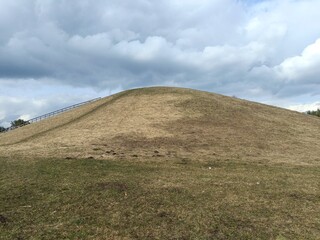 Salduve hill during cloudy day. Small hill. Grass is growing on hill. Staircase leading to the top....