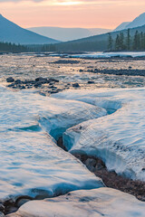Snow and ice on the banks of the river Hoisey. Polar day on Putorana Plateau, Russia