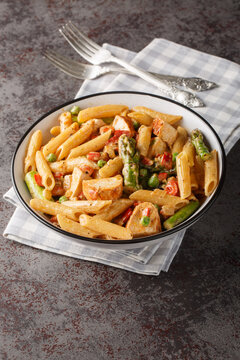 Mexican Creamy Chicken Chipotle Pasta with vegetables closeup in the bowl on the table. Vertical