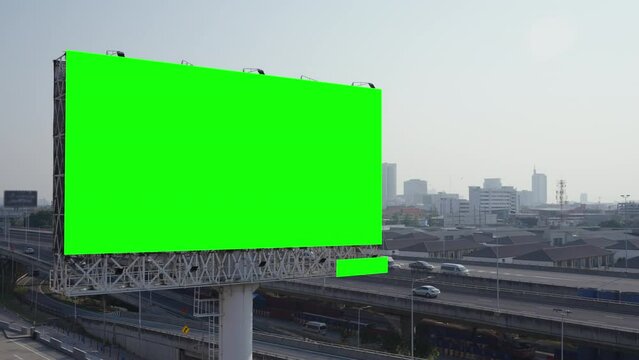 A large blank billboard towers over a busy city street