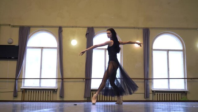 Graceful ballerina dancing elements of classical ballet in the dance studio