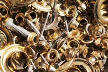 Metal elements background. Golden color clothing snaps. Repair box. Screws, nails and various size jacket snaps texture.