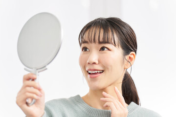鏡で歯並びをチェックする女性