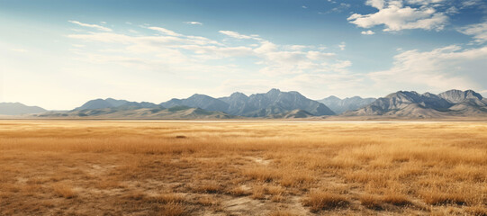 Scenic prairie landscape with majestic mountains in the distance, under a vast blue sky. - 786991154