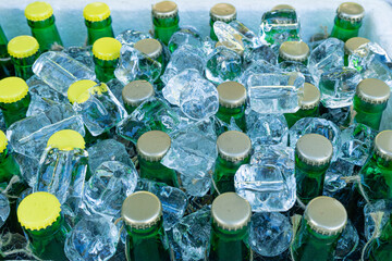 Beer Bottles in Ice Cubes, Many Cold Bottle Caps in Box, Iced Chilled Beer Chest, Different Cold Bottles