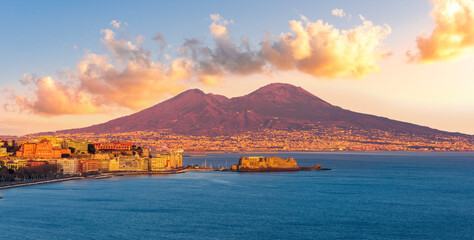 beautiful panorama of volcano Vesuveus from Naples with blue water of sea gulf, majectic mountain and amazing cloudy sunset sky on background
