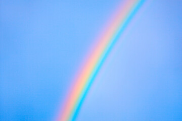 Vibrant rainbow arc across the brilliant blue sky. Stunning contrast of colors