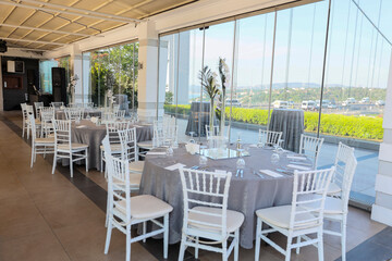 The elegant wedding table ready for guests. Decorated white wedding table for a festive dinner with...