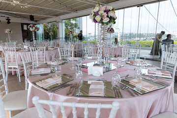 The elegant wedding table ready for guests. Decorated white wedding table for a festive dinner with...