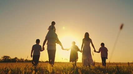 Little daughter on shoulders of Dad, mom, son, walk hand in hand outdoor. Big family, group of...