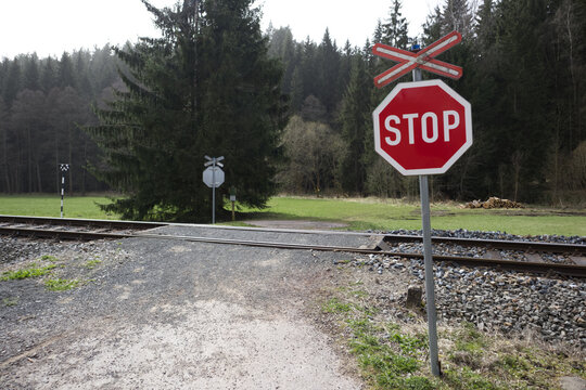 Stop sign at a railway crossing in a forest road