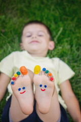a smile drawn with paints on a child's legs