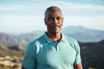 Portrait of a glad afro-american man in his 50s donning a classy polo shirt in front of panoramic mountain vista