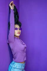Portrait of elegant beautiful Asian woman in fashionable clothes around colorful bright violet...