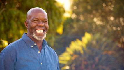 Portrait Of Smiling And Laughing Senior Man Outdoors In Countryside Or Garden