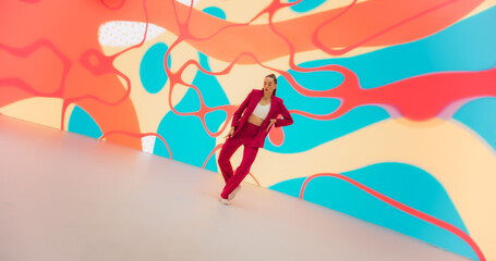 Portrait of Talented Energetic Woman Dancing with Energy: Athletic Female Dancer Performing a Modern Choreography in a Studio with Colorful Funky Background. Making Moves, Practicing Her Routine
