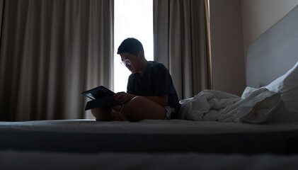 Boy using digital tablet on bed