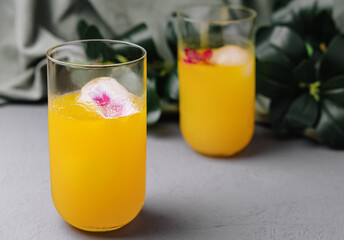 Refreshing orange cocktail with floral ice cubes