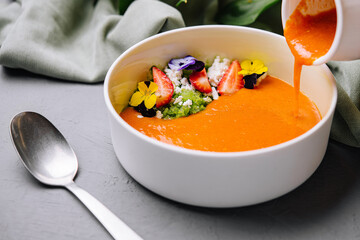 Gourmet pumpkin soup with edible flowers