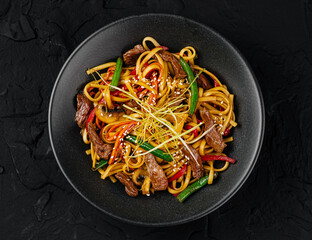 Asian stir-fried noodle dish on dark background