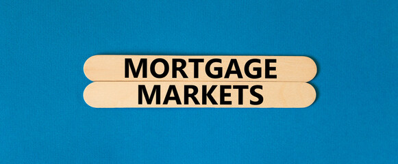 Mortgage markets symbol. Concept words Mortgage markets on beautiful wooden stick. Beautiful blue table blue background. Business mortgage markets concept. Copy space.
