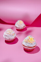 Colorful cupcakes on pink background