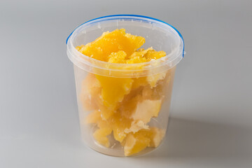 Crystallized honey in open plastic container on a gray background - 787046152