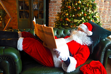 Santa claus reading business newspaper while sitting on sofa