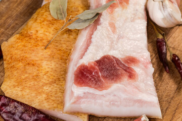 Salted pork fatback pieces among different spices on cutting board - 787046352