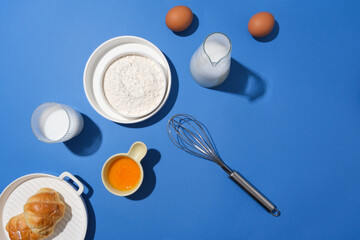 Blue background against on essential baking ingredients from top view, copy space for adding text. Photo for bakery or dining store