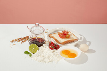 Layout with some essential ingredients for preparing simple breakfast in morning, rich in protein, calcium and vitamins. Empty space for advertising on pink background