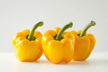 Juicy yellow bell peppers falling gently onto a blank white canvas, creating a vibrant and colorful display.