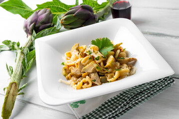 Piatto di deliziose orecchiette condite con carciofi, pasta italiana vegetariana, cibo mediterraneo  - 787052178