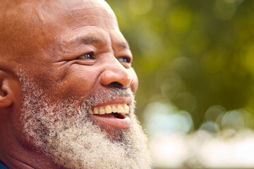 Close Up Portrait Of Smiling Senior Man Outdoors In Countryside Or Garden