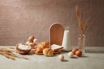 Cement background with some baking ingredients displaying on gray table including sandwich,...