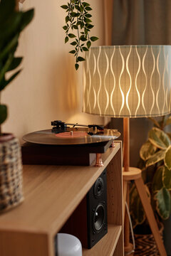 Vertical background image of vinyl record player on wooden shelf in cozy home interior copy space
