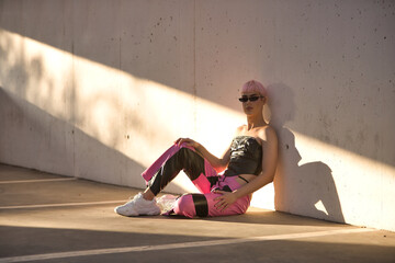 Attractive young gay man, heavily makeup, with pink hair, sunglasses, leather top and pants,...