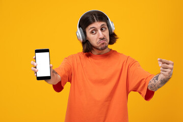 Shocked astonished middle eastern man wearing casual style posing isolated over yellow background,...